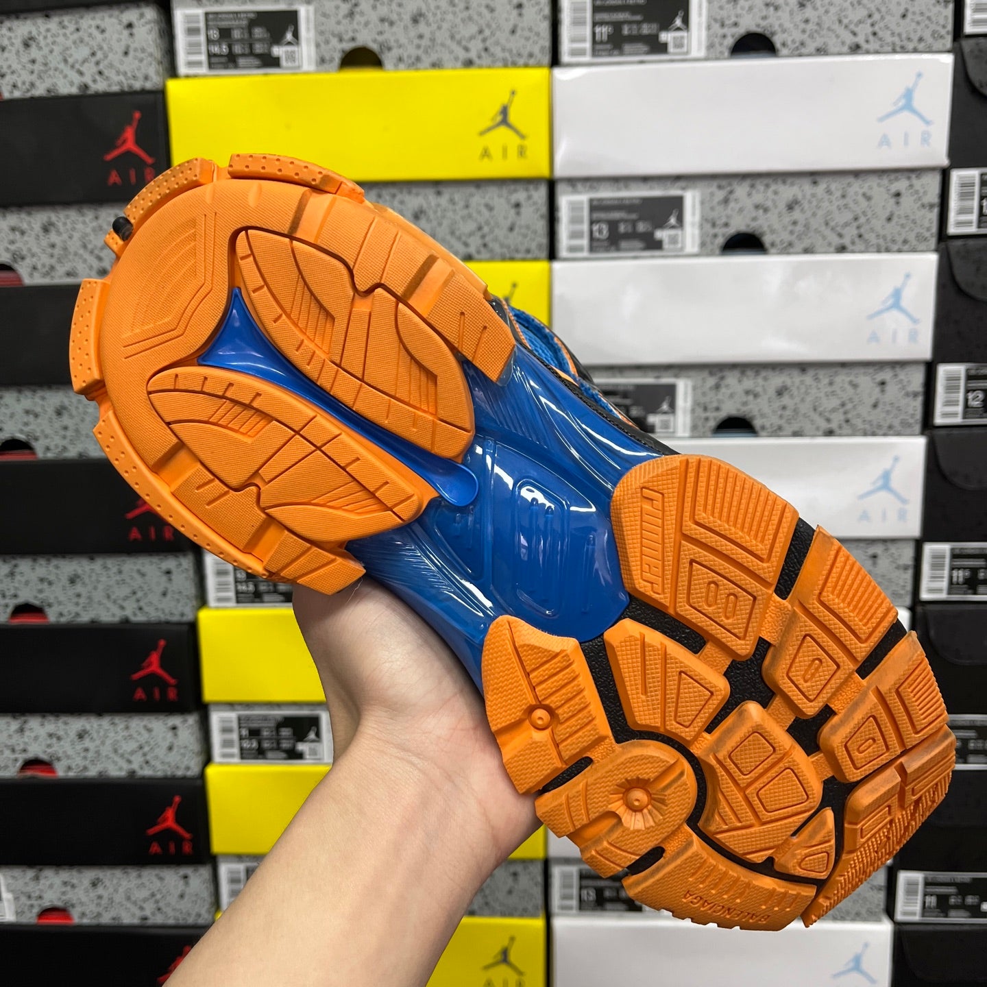 High-top unisex sneakers outsole view: blue tread with orange rubber grips
