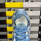Blue lace-up sneaker toe with textured paneling and laces