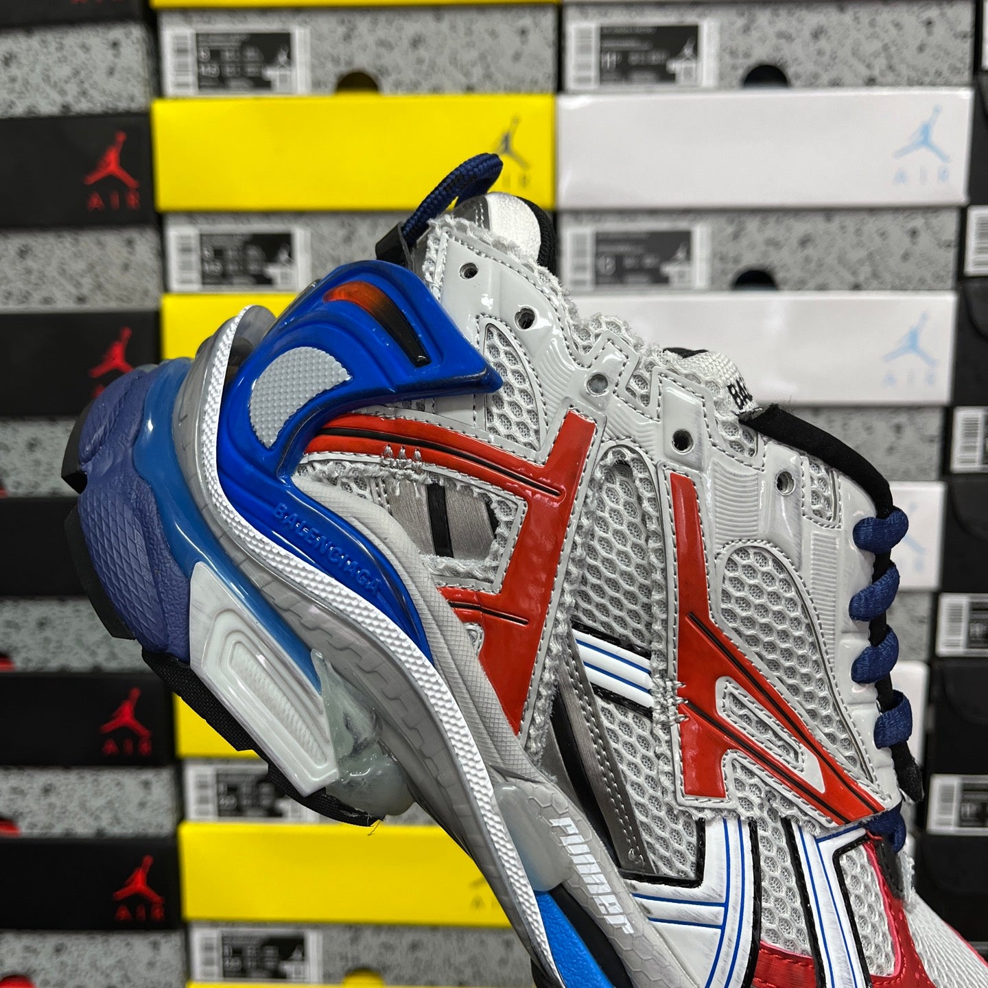 Unisex sneakers quarter view in white with red center panel and blue collar