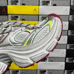 Silver sneaker side view with red lining and green-yellow accent panel details.