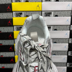 Silver sneaker back view with padded collar, lace ties, and textured paneling.