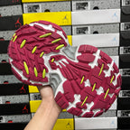 Red and white outsole with green-yellow traction nubs and deep molded grooves.