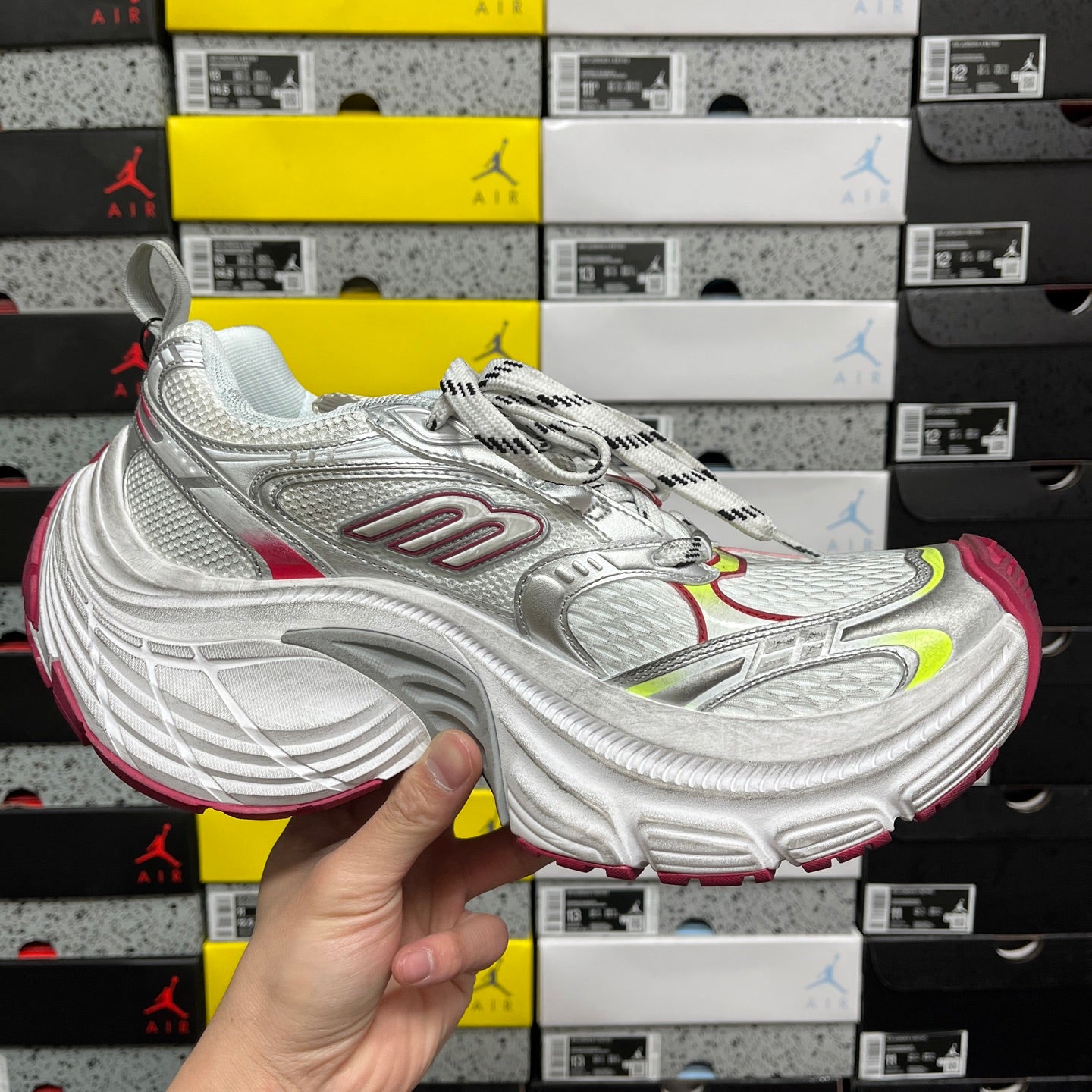 Silver lace-up sneaker with red and green accents and thick cushioned sole profile.