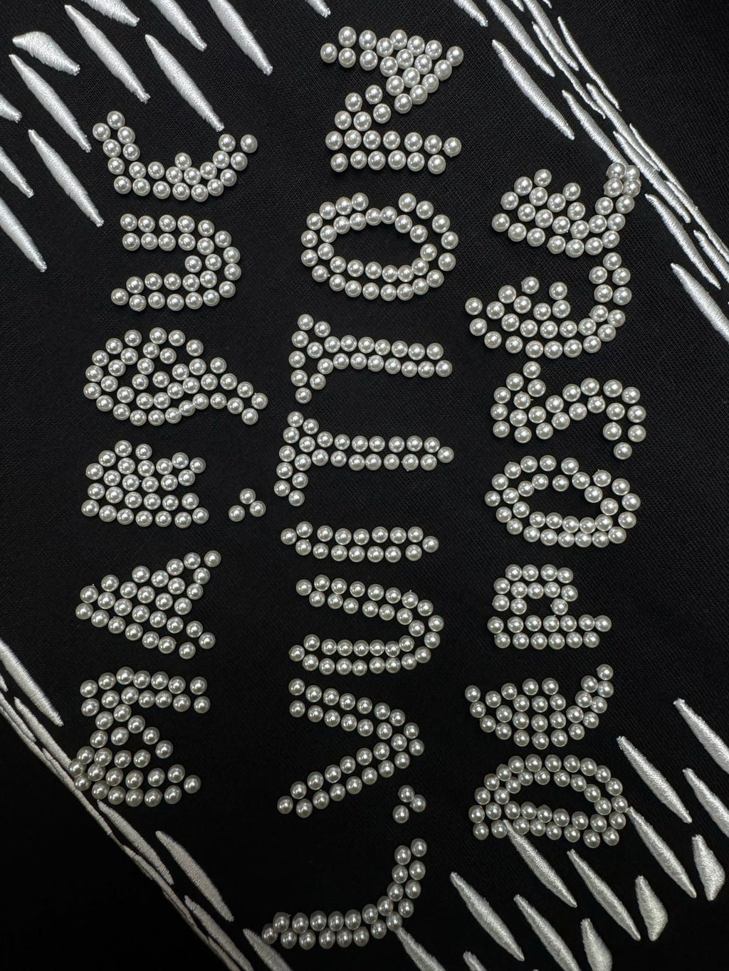 Louis Vuitton black T-shirt close-up of sparkling rhinestone lettering graphic