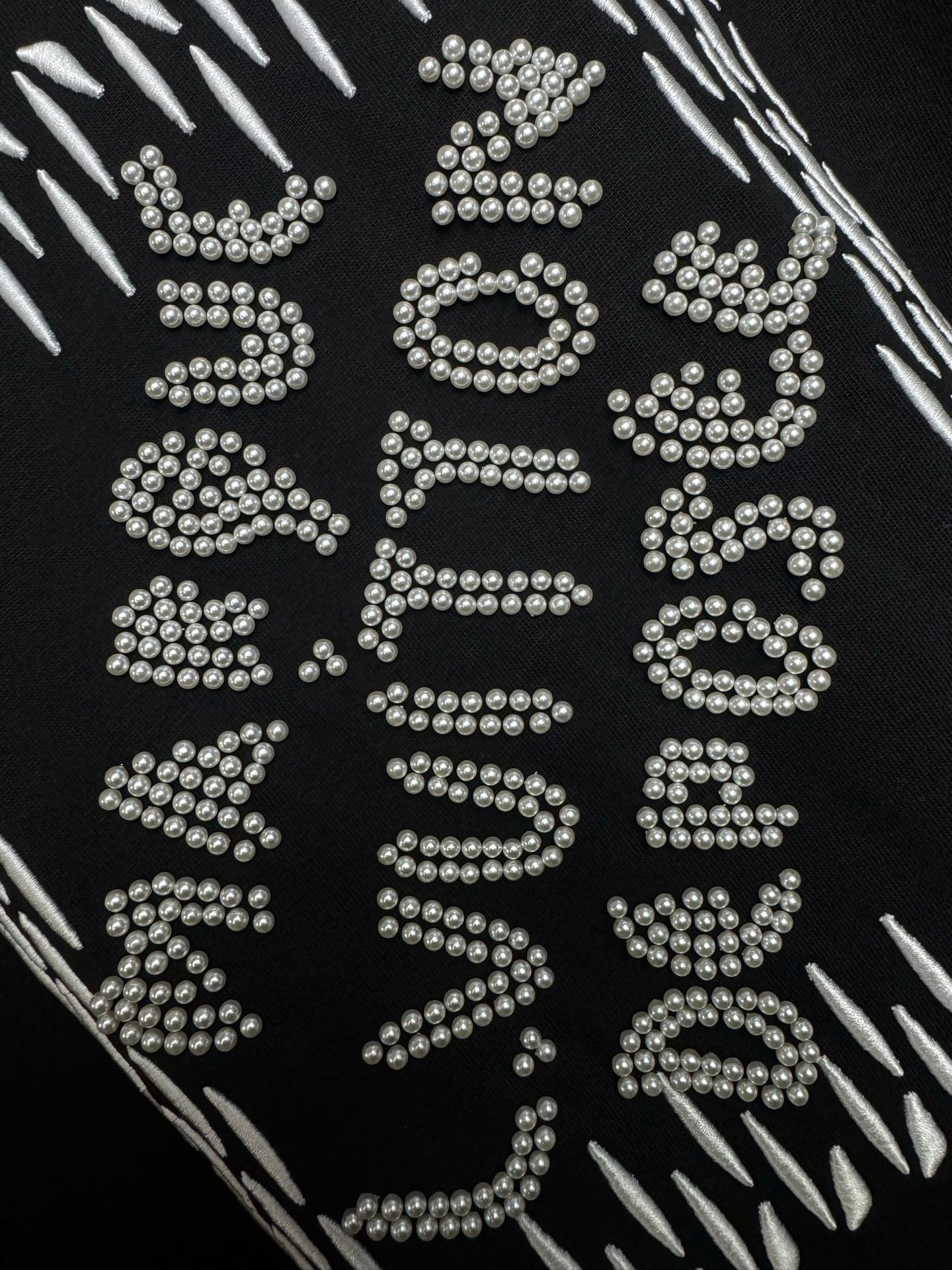 Louis Vuitton black T-shirt close-up of sparkling rhinestone lettering graphic