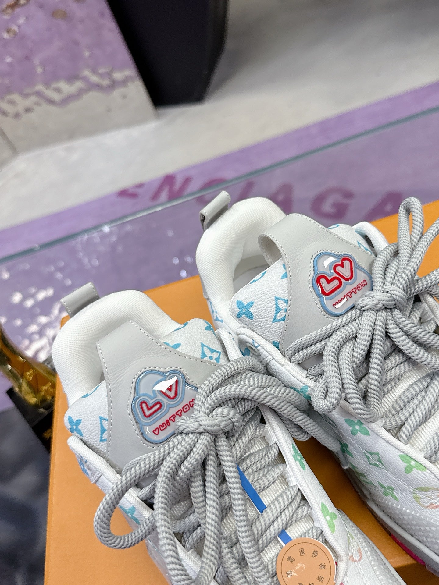Louis Vuitton ladies sneakers, white with colorful logo patches on tongue and gray laces