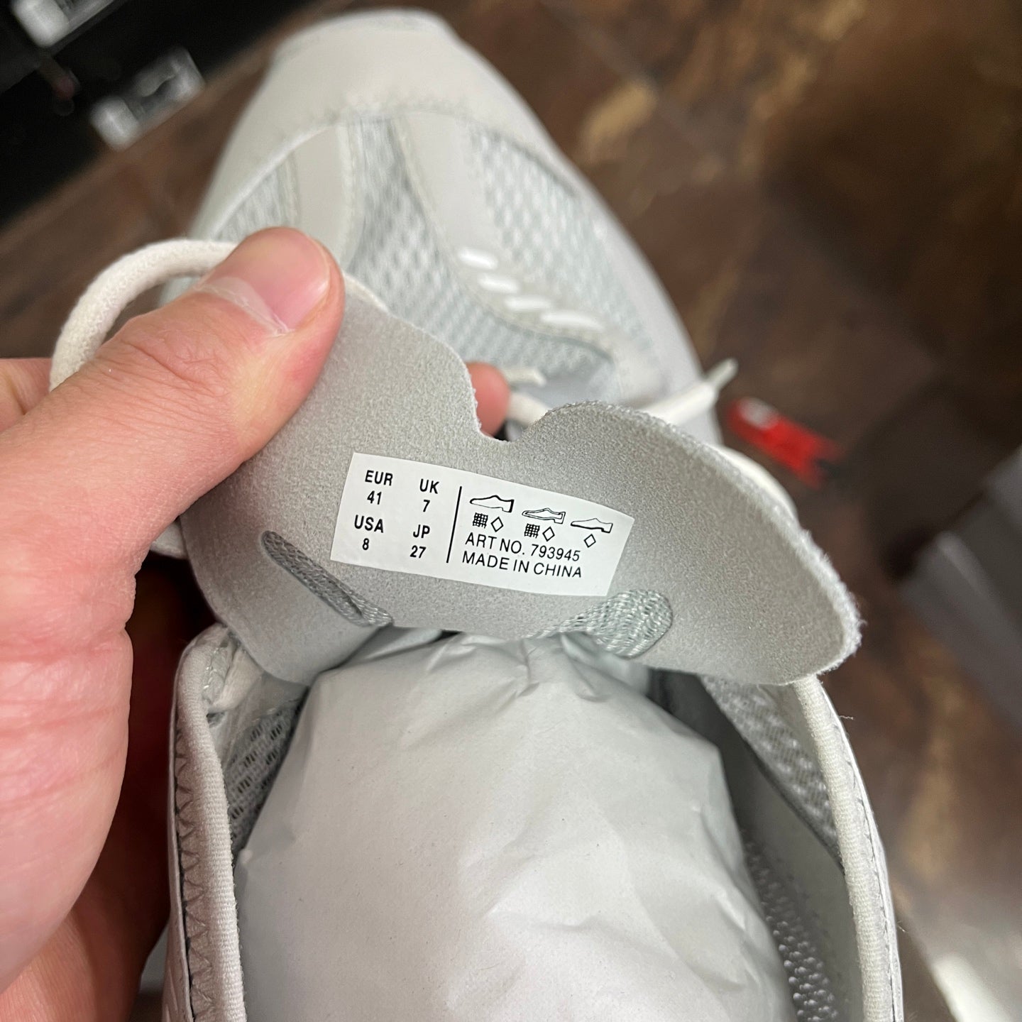 Light gray sneaker size label inside tongue with measurement details