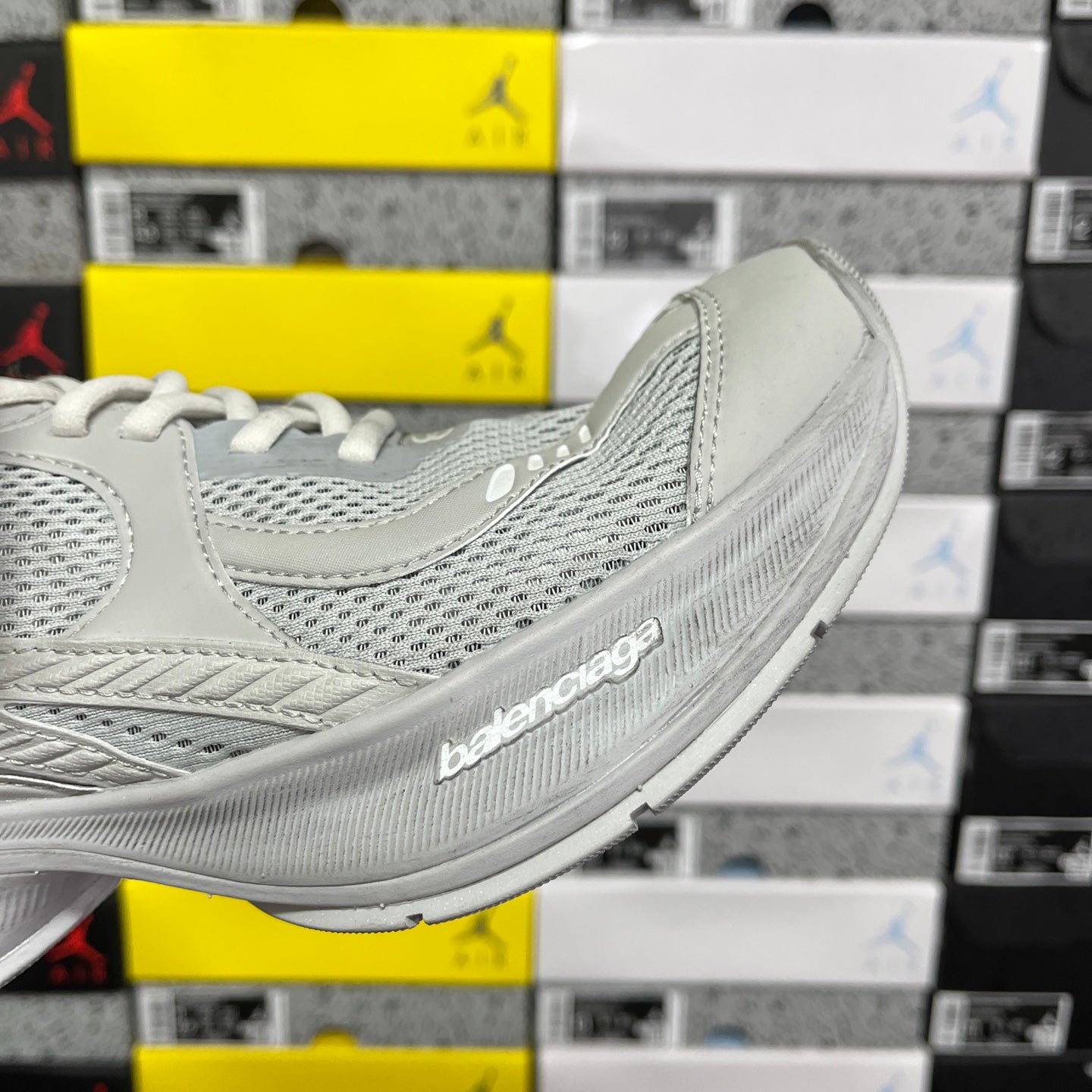 Light gray mesh sneaker side view with textured sole and Balenciaga logo
