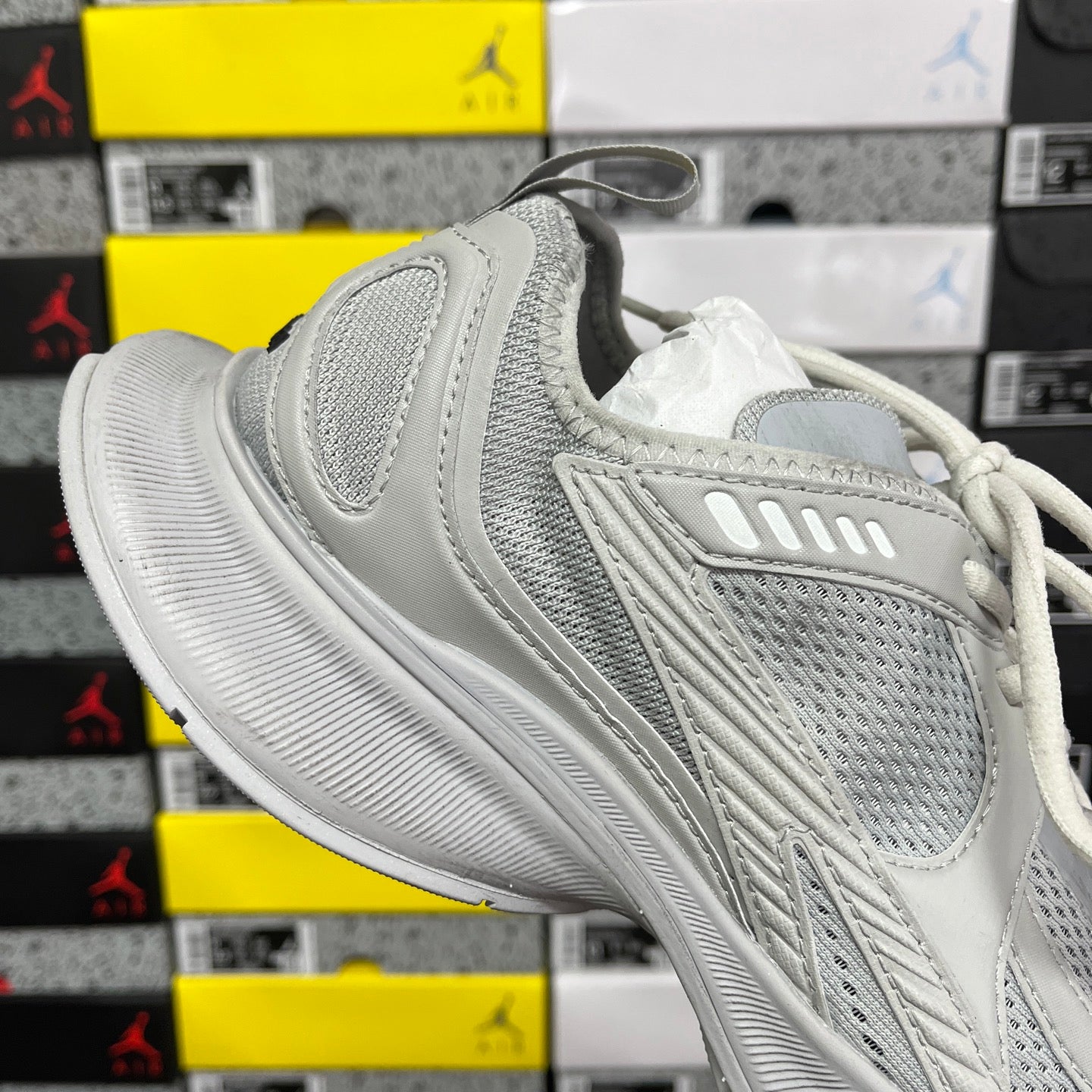 Light gray mesh sneaker with curved side stripes and white laces