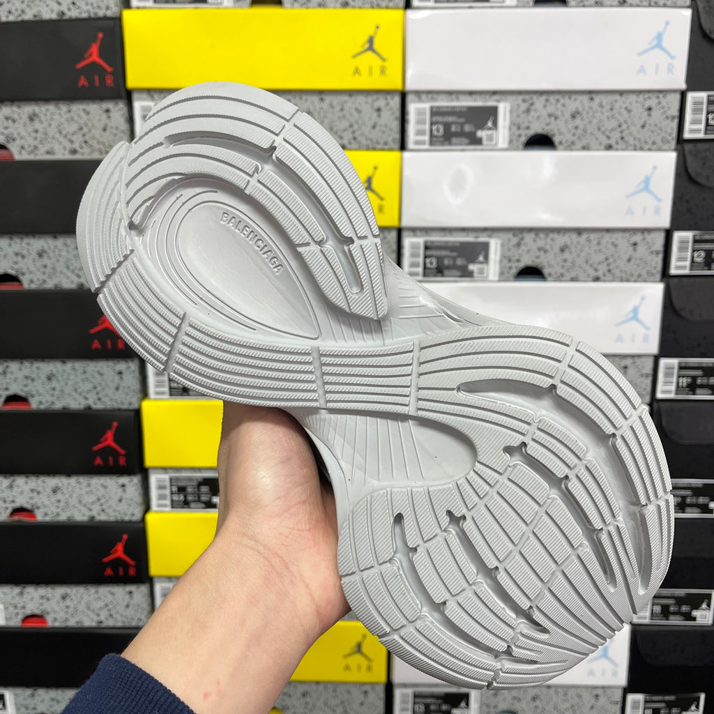 Light gray sneaker outsole with patterned tread and side logo mark