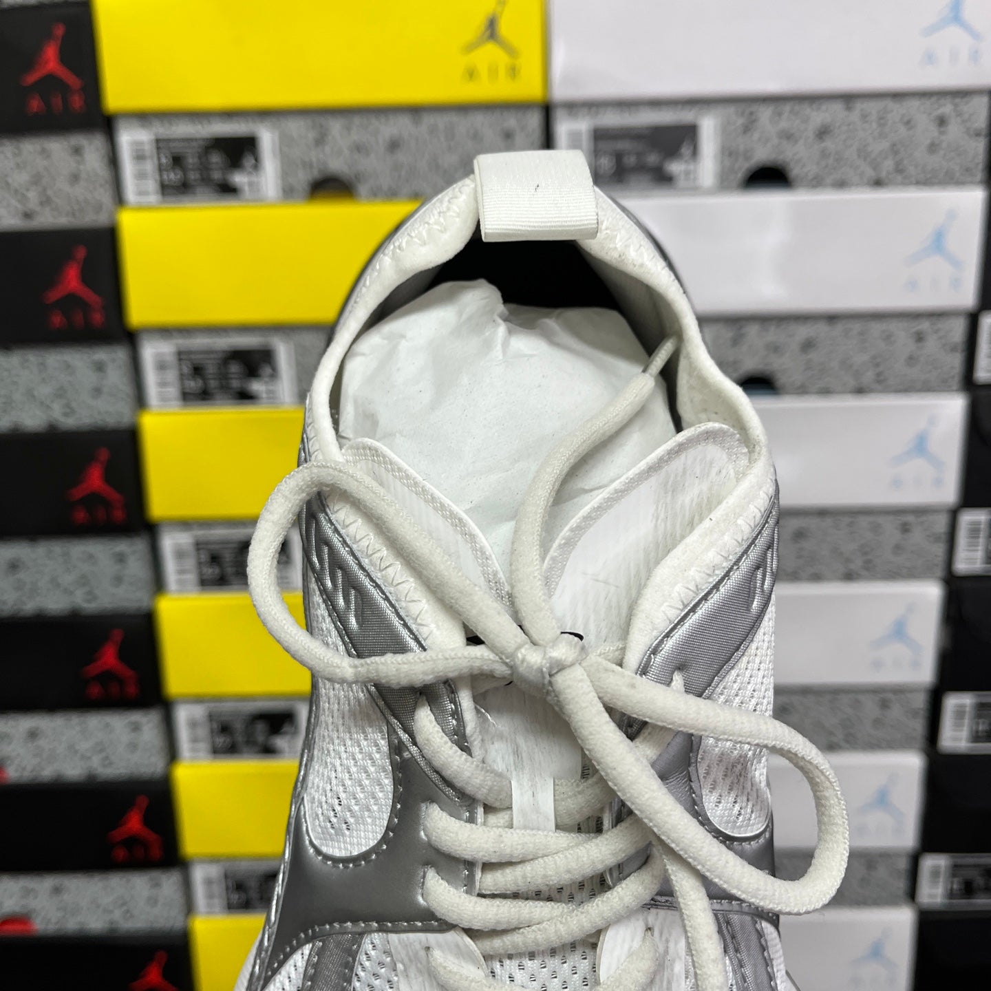 Silver and white sneaker tongue and lace area with padded inner lining.