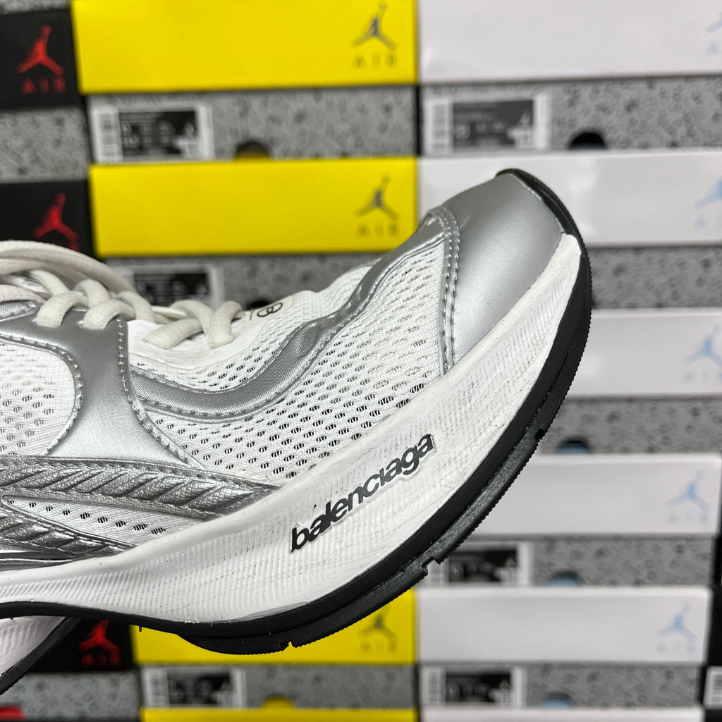 Silver and white mesh sneaker side detail with Balenciaga logo on midsole.