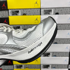 Silver and white mesh sneaker side detail with Balenciaga logo on midsole.