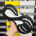 Black and white sneaker outsole with tread pattern and flex grooves.