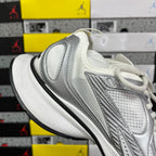 Silver and white mesh lace-up sneaker with textured overlays and black sole.