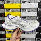 Unisex white sneaker with purple accents, side profile view