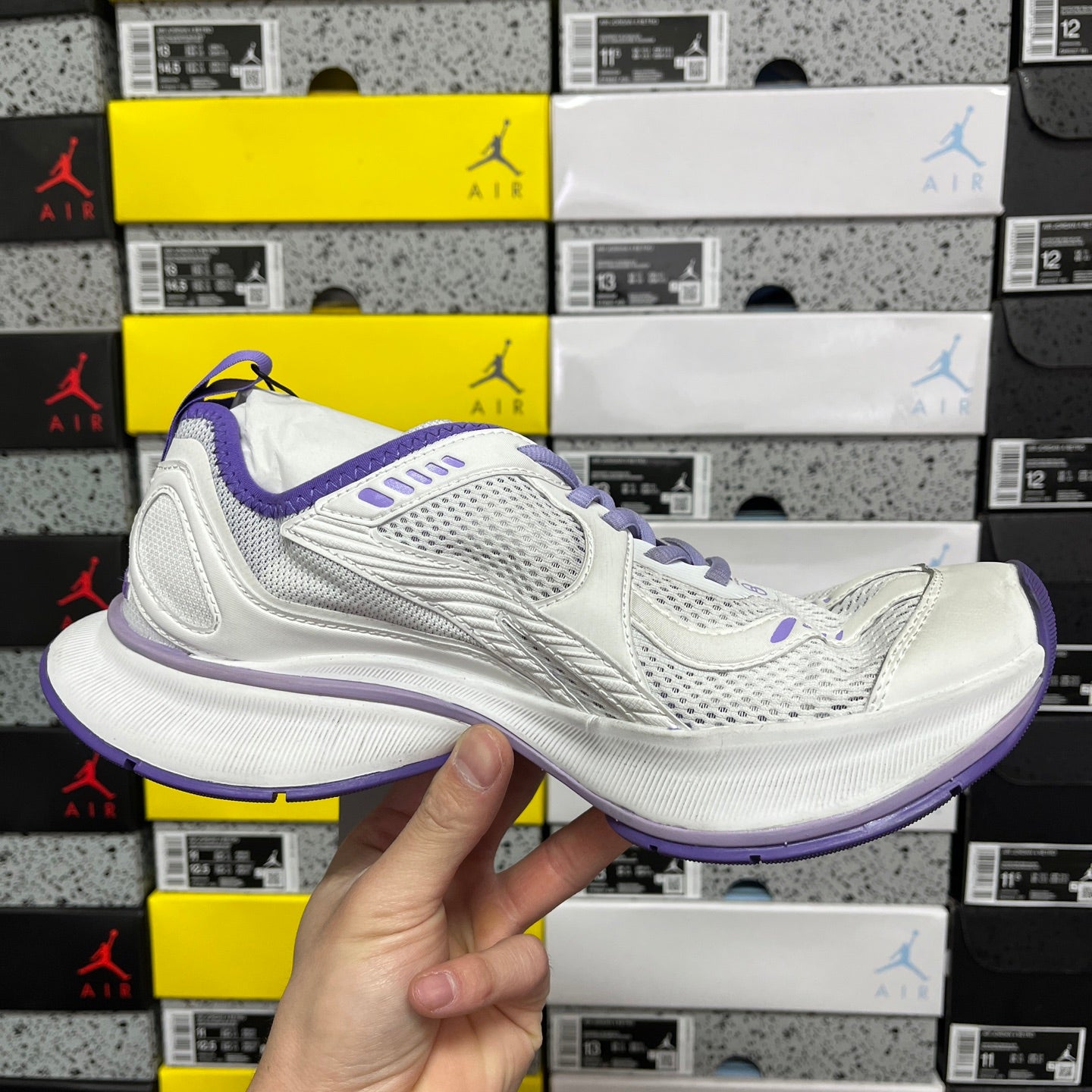 Unisex white sneaker with purple accents, side profile view