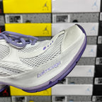 Unisex white sneaker with purple outsole edge and side stitch details