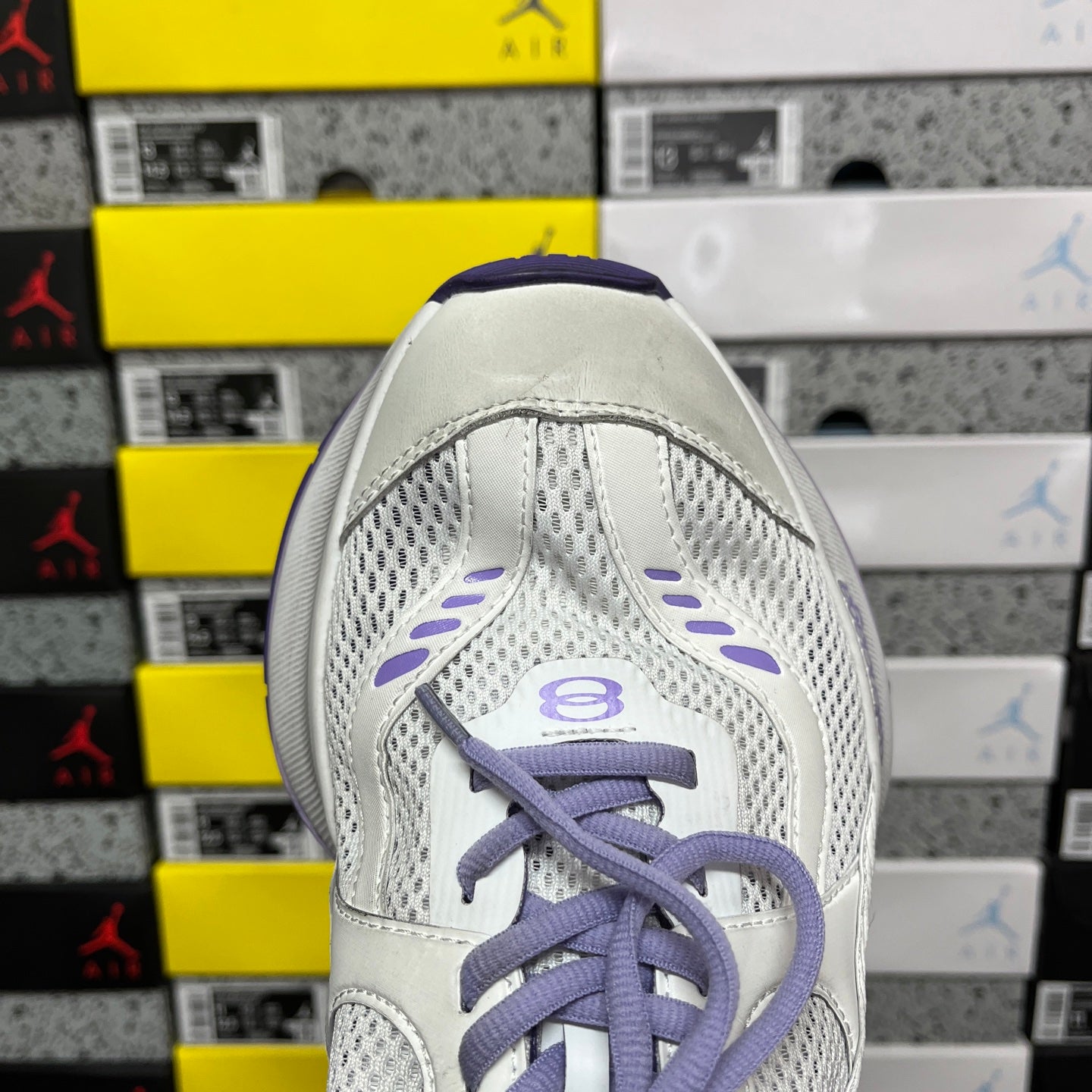 Unisex white sneaker with mesh panels and purple laced top