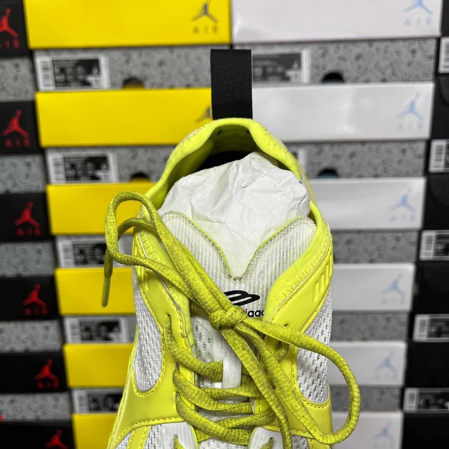 Back view of lime green and white Balenciaga sneaker with heel pull tab and laces