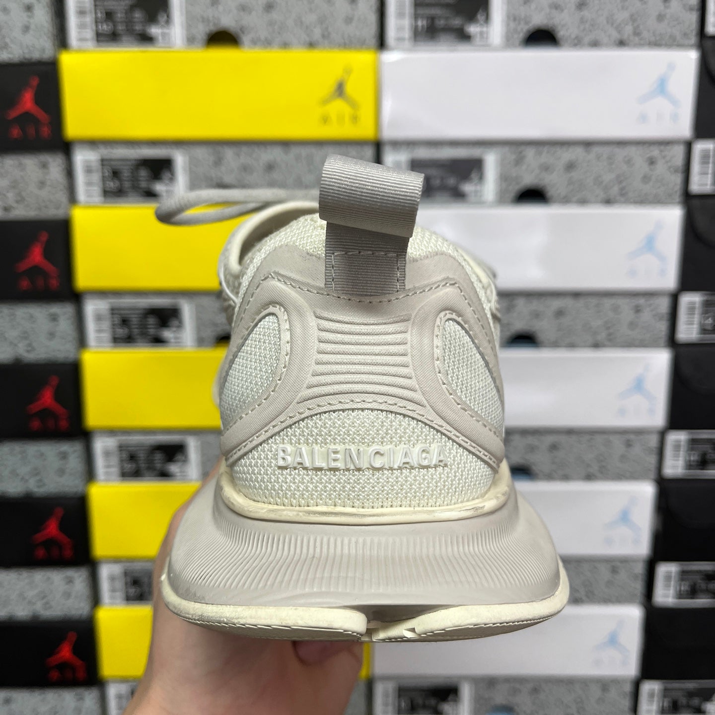 Off-white running shoe back view with fabric heel loop and BALENCIAGA logo