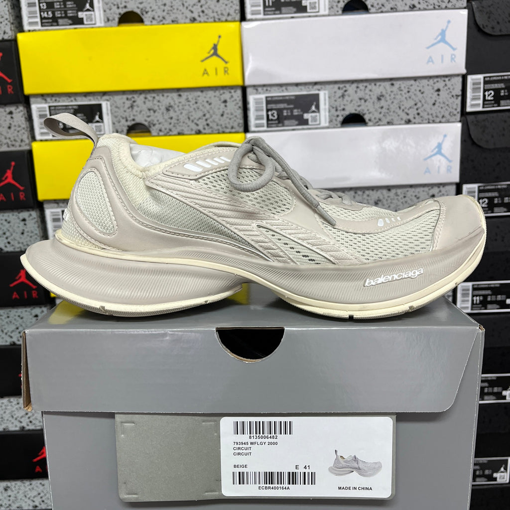 Off-white lace-up running shoe on a box, with cushioned sole and mesh upper