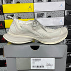 Off-white lace-up running shoe on a box, with cushioned sole and mesh upper