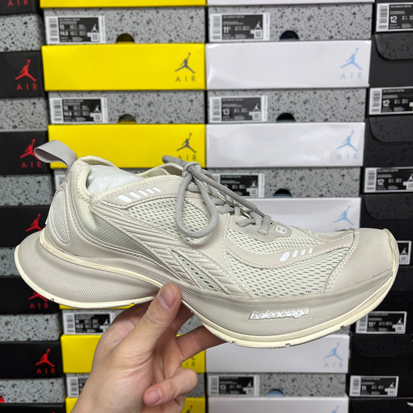 Off-white lace-up running shoe with breathable mesh and stitched panel overlays