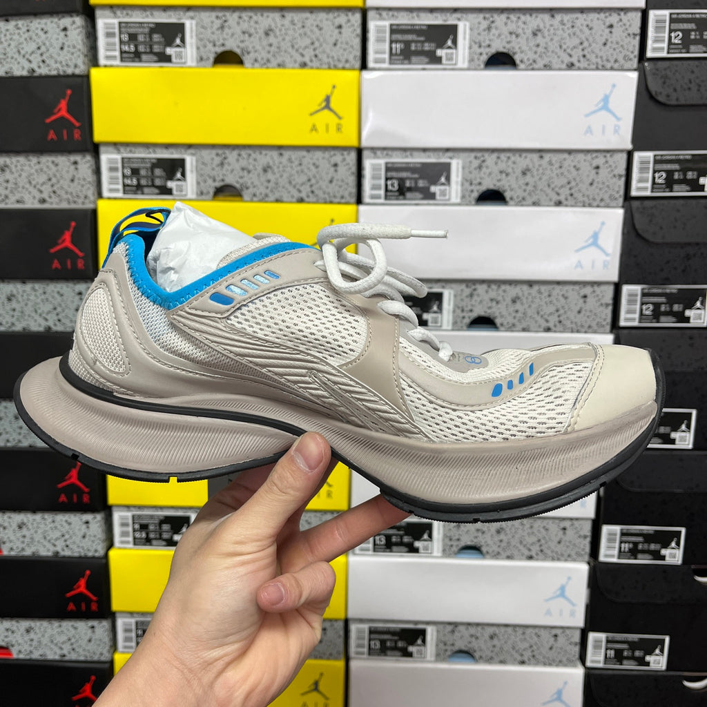 Balenciaga unisex sneakers in light beige with blue trim and white laces, front side view