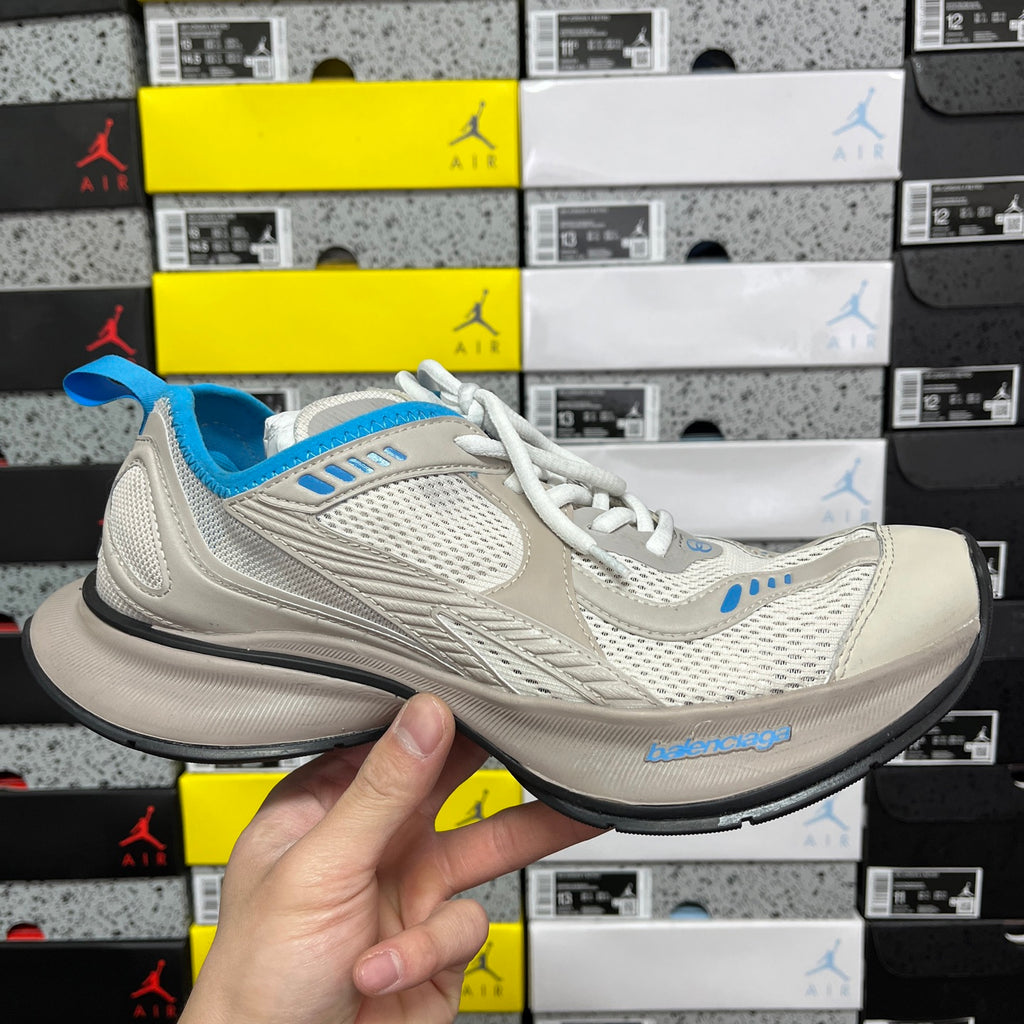 Balenciaga unisex sneakers in light beige with white laces and blue accents, side view