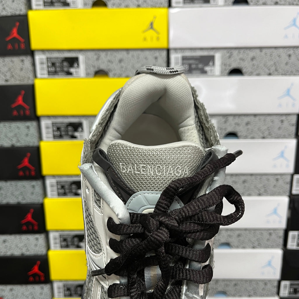 White and gray sneaker collar with black laces and BALENCIAGA logo on heel tab.