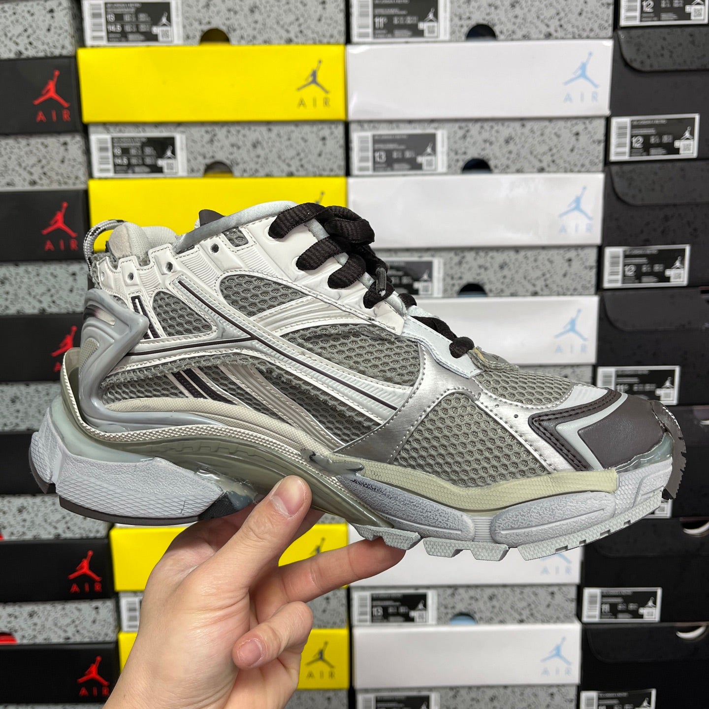White and gray unisex sneaker with black laces, mesh panels, and cushioned sole.
