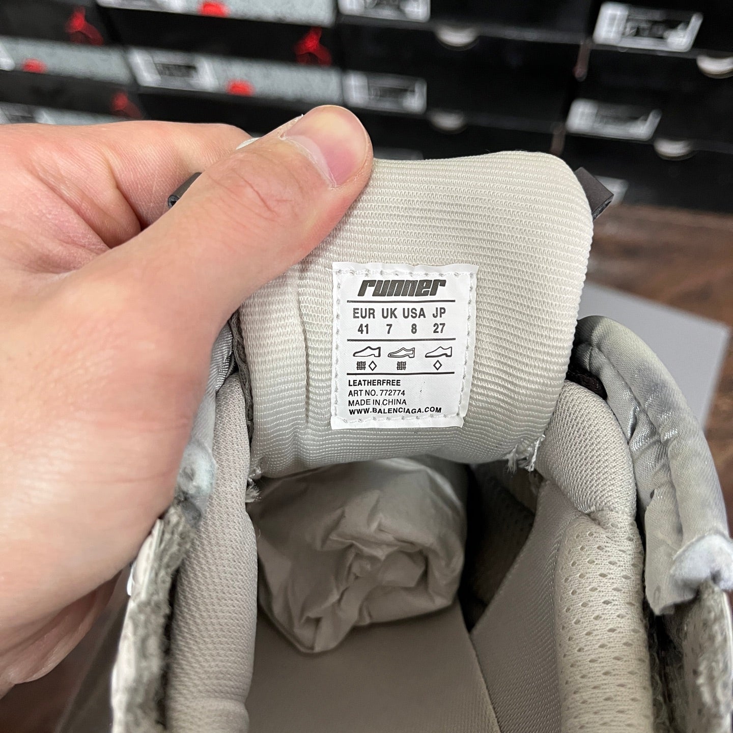 Cream sneaker interior with fabric size label and printed sizing chart.