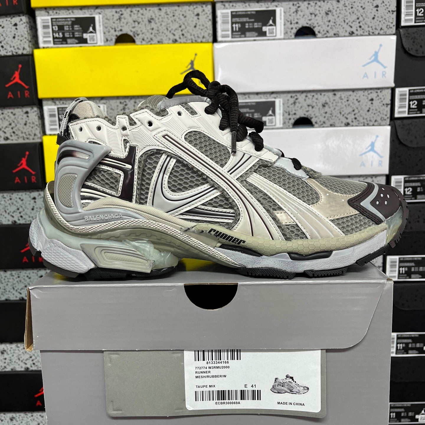 White and gray unisex sneakers with black laces and thick cushioned sole.