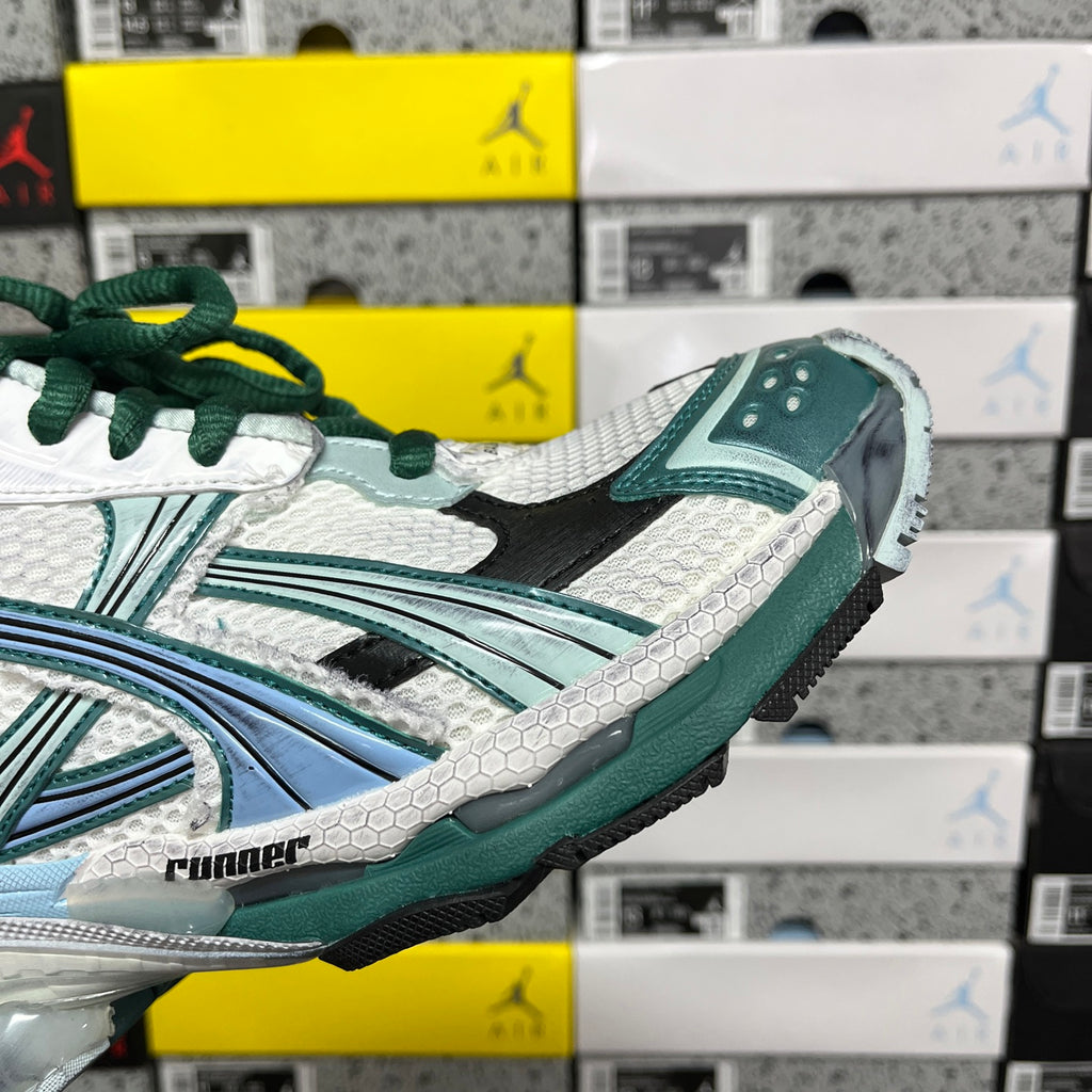 Runner sneaker side close-up with white mesh texture, teal trim, and green laces.