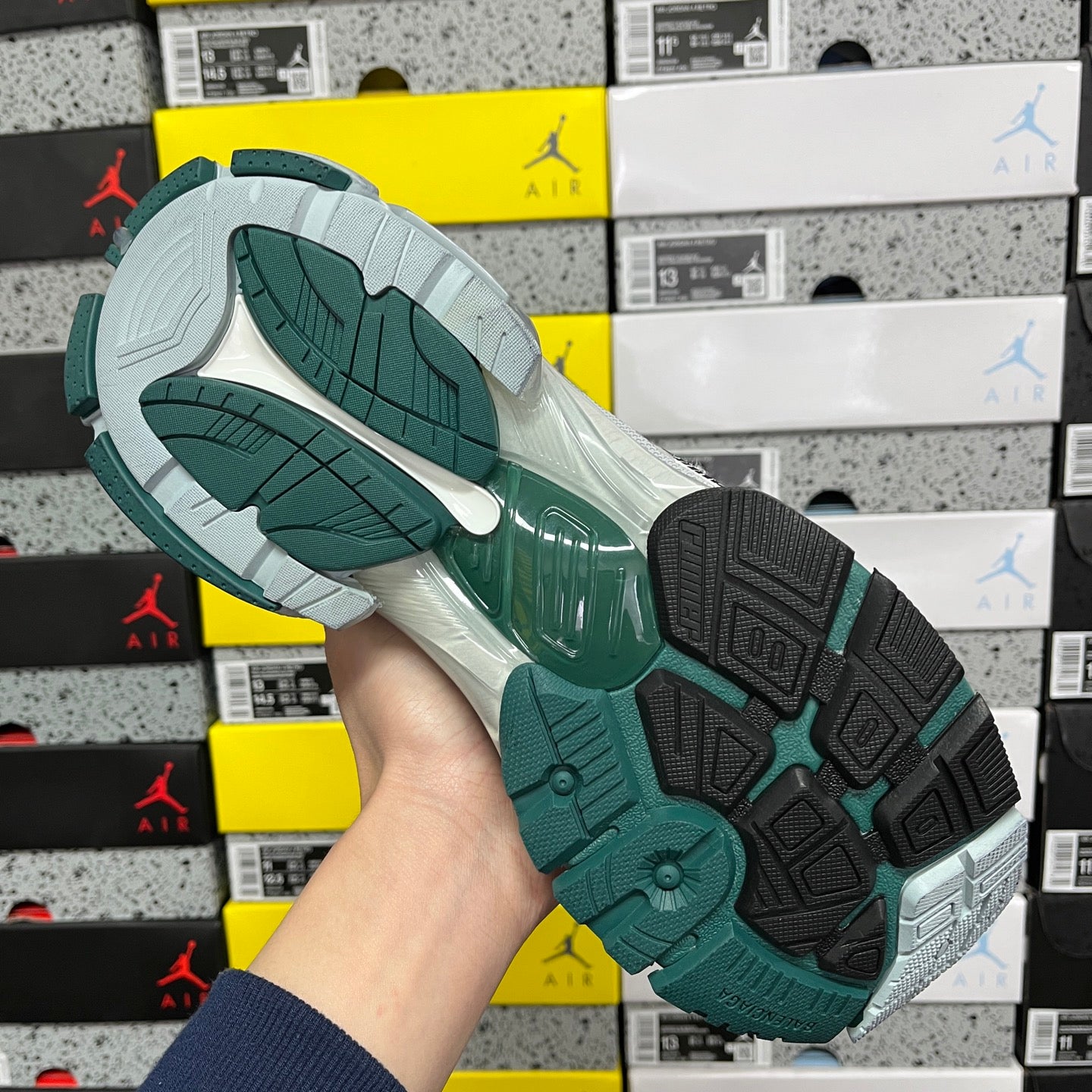 Runner sneaker outsole with textured traction, teal rubber sections and gray base.