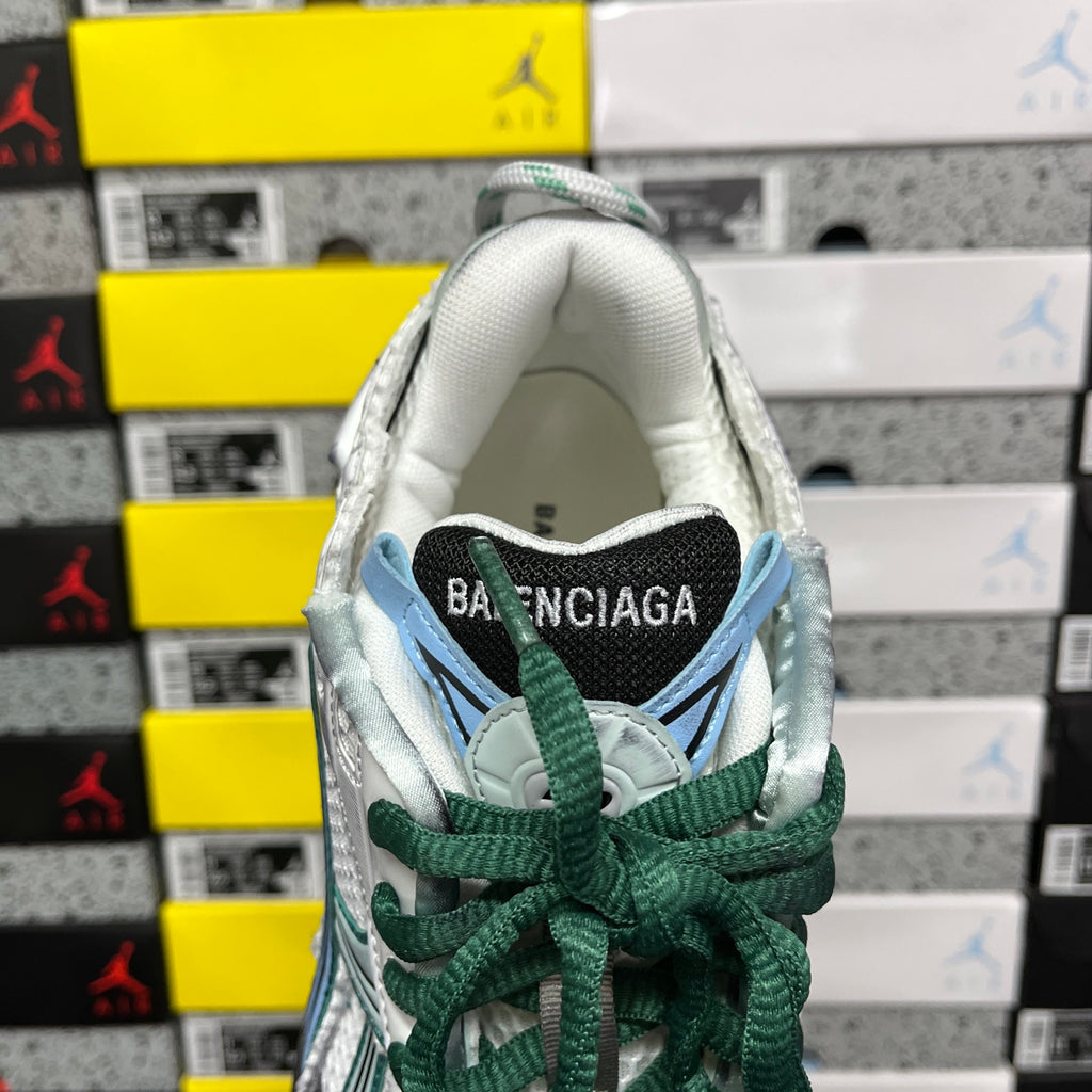 Runner sneaker heel with Balenciaga label, white lining, green laces, teal accents.