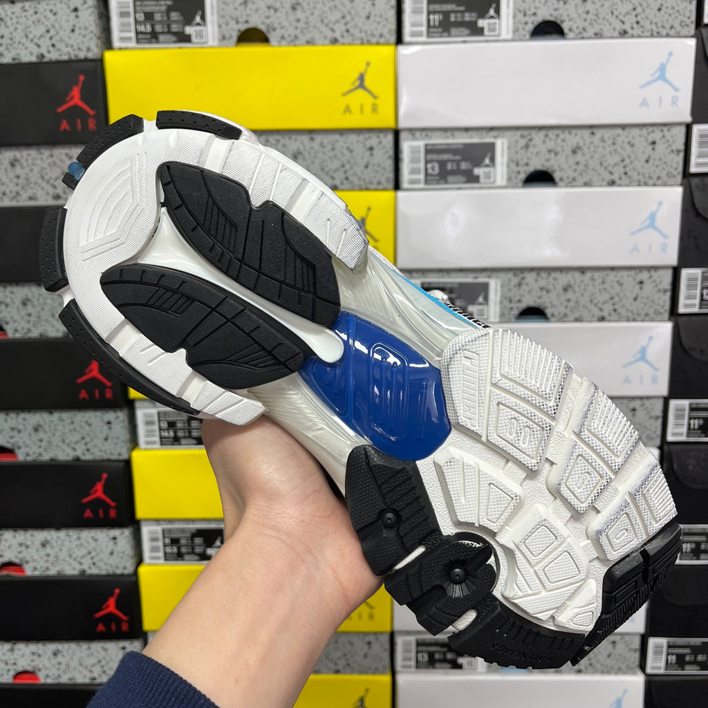 Shoe outsole with black and white tread and blue heel detail