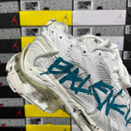 White sneaker quarter panel with teal-blue graphic and stitched overlays.