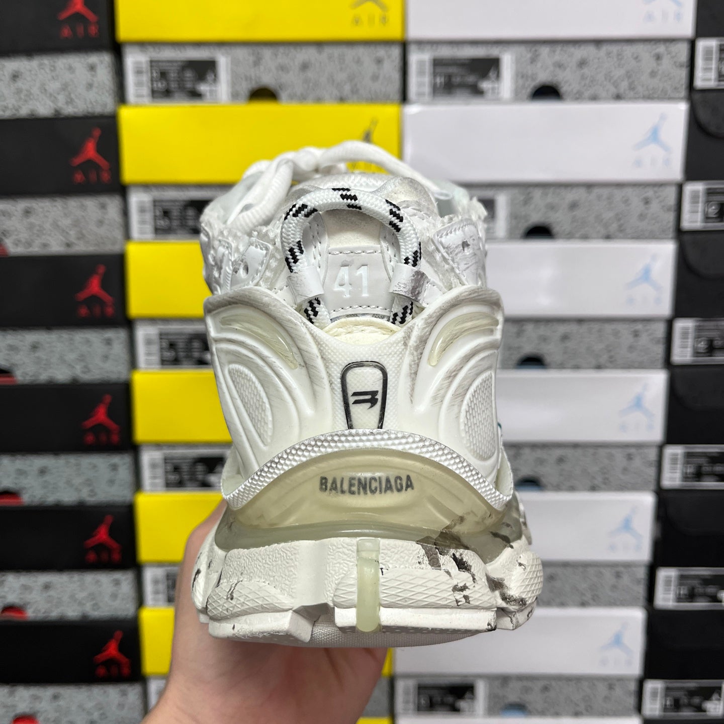 White sneaker heel with 'BALENCIAGA' emblem and thick midsole cushioning.