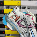 White Balenciaga runner sneaker side with orange and black stripes and blue sole edge