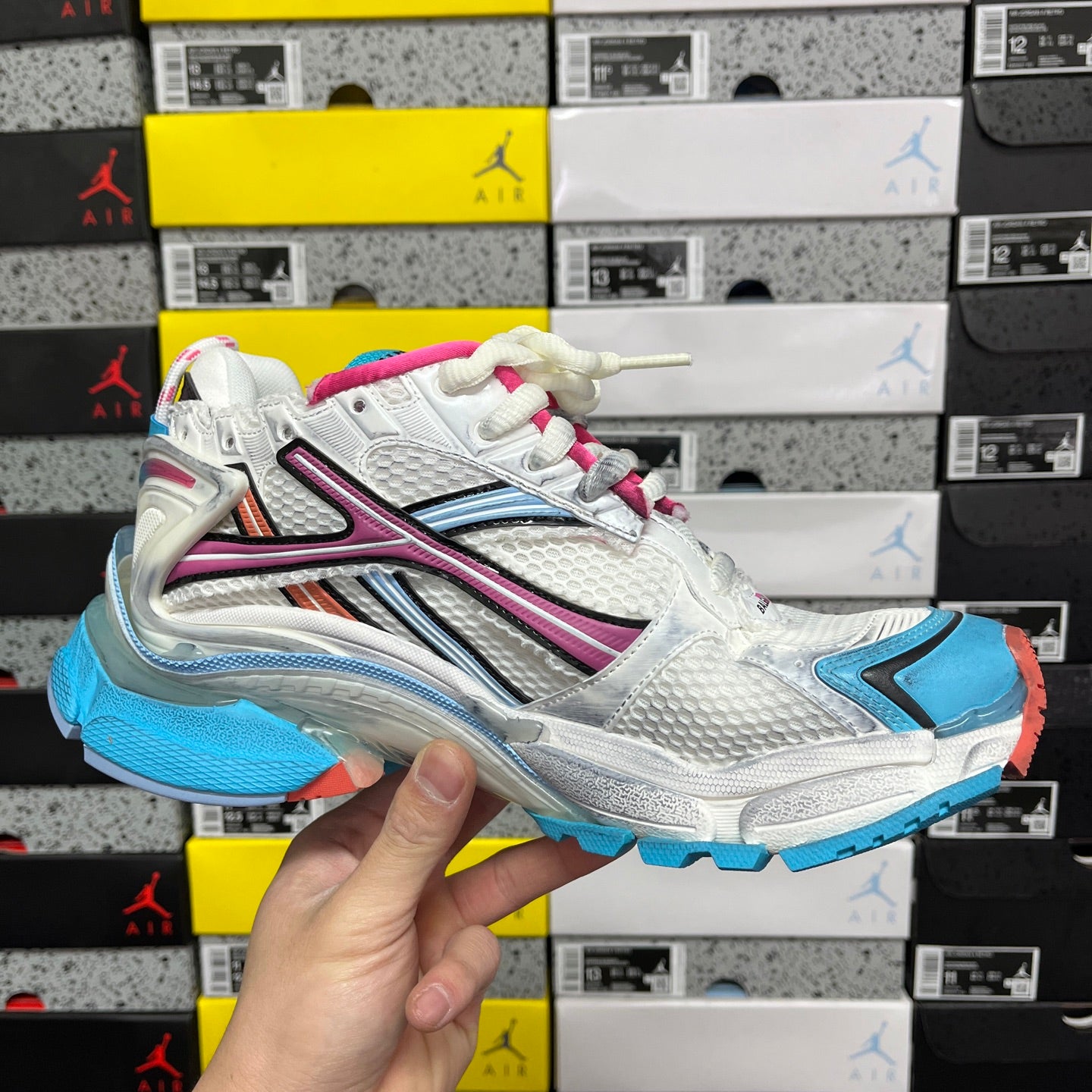 White Balenciaga runner sneaker angled view with blue panel and magenta stripe