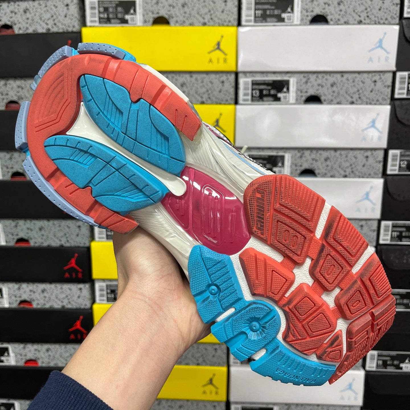 White Balenciaga runner sneaker front view with blue side panel and red sole edge