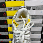 White Balenciaga unisex sneaker with yellow pull tab and white lace-up tongue