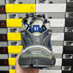 Blue running sneaker with gray heel, exposed cushioning, and visible branding