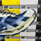 Blue running sneaker side with white overlays, gray trim, and sculpted sole