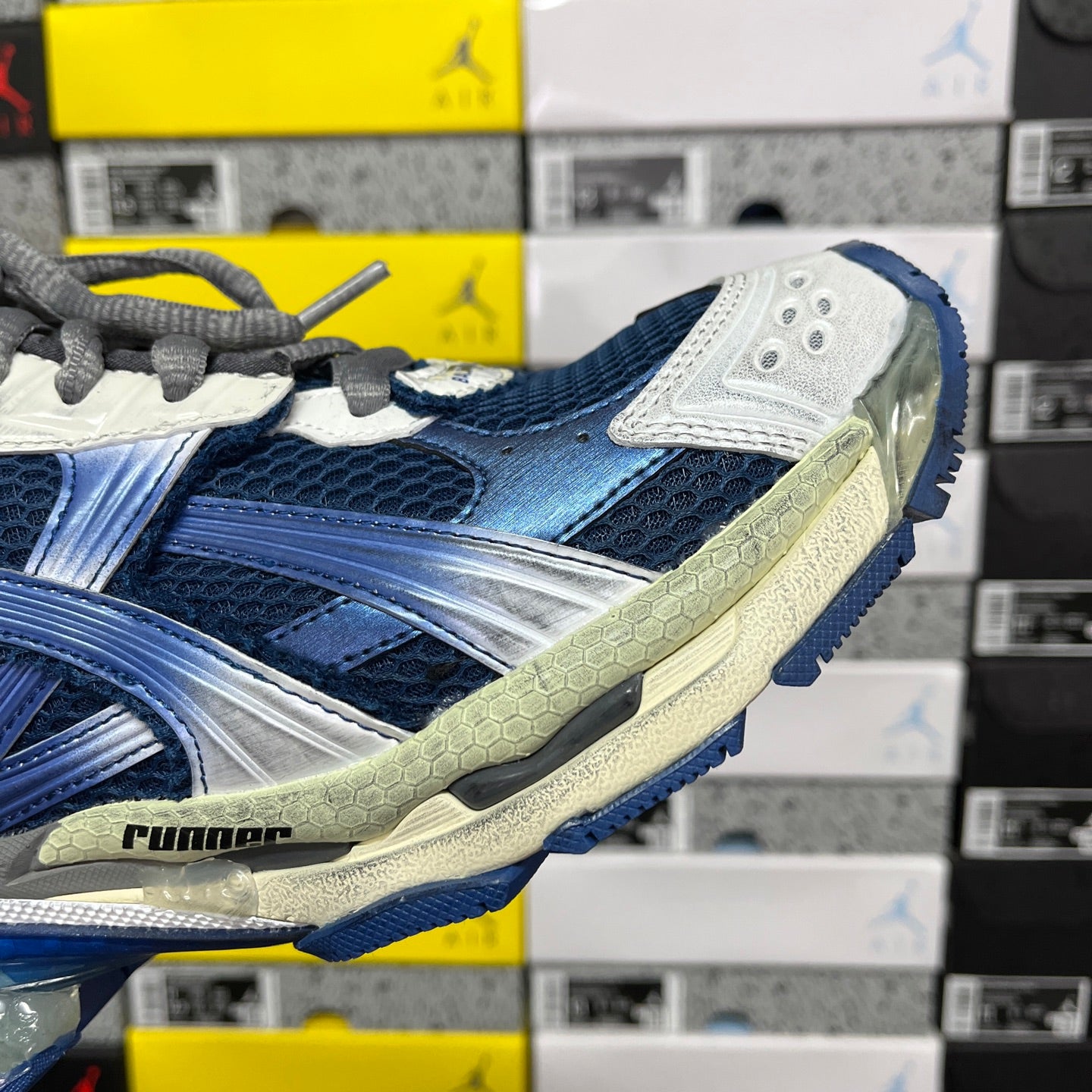Blue running sneaker side with white overlays, gray trim, and sculpted sole