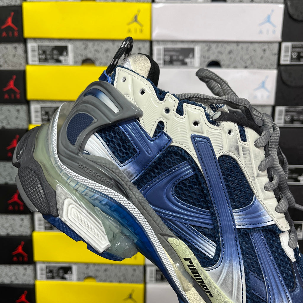 Blue and white running sneaker heel with gray lace-up strap detail