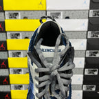 Blue and white sneaker with gray laces and black heel collar