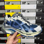 Blue and white running sneaker with gray laces and molded side panels